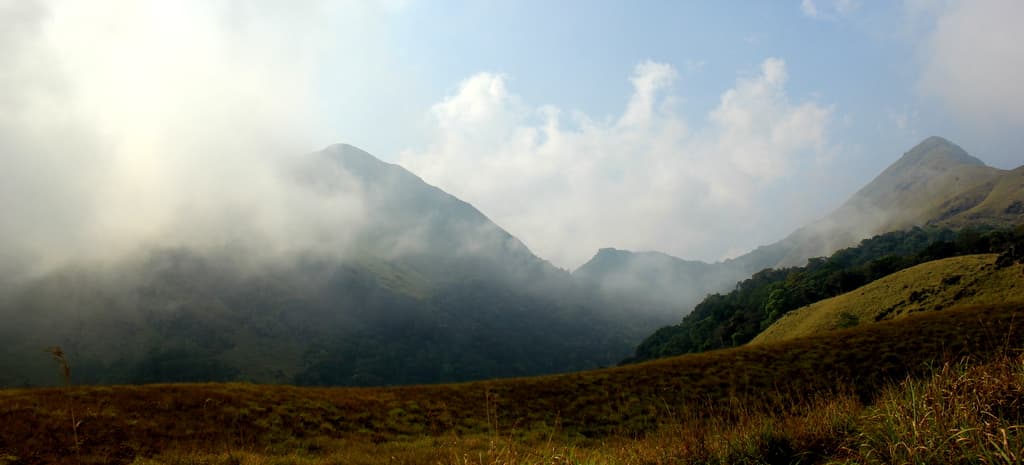 Mist drifting between the grassy slopes of Chembra Peak